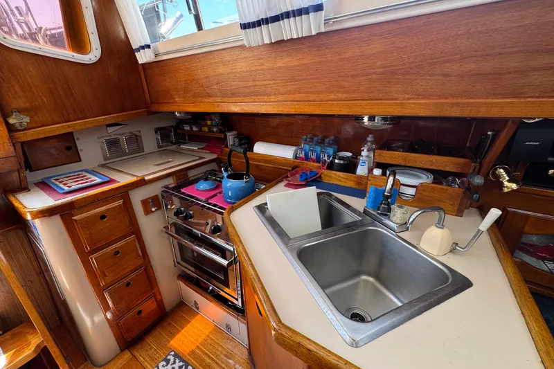 Slide: The Image of 1989 Gulf Pilot House kitchen with wooden cabinetry, stove, and dual sink. - 31