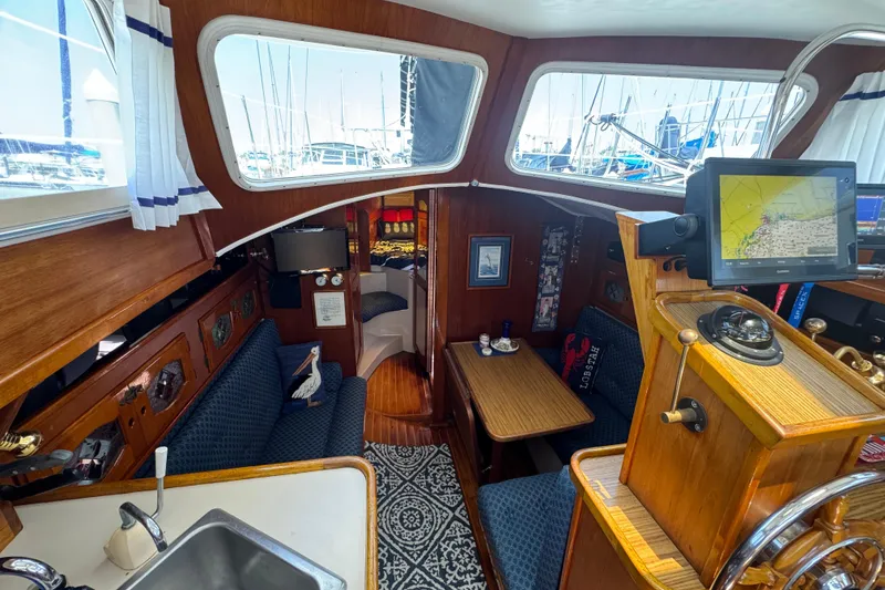 Slide: The Image of 1989 Gulf Pilot House interior with nautical decor, featuring navigation equipment and cozy seating. - 34