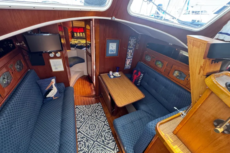 Slide: The Image of Cozy 1989 Gulf Pilot House interior with blue seating, wooden accents, and nautical decor. - 35