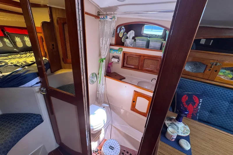 Slide: The Image of Interior of a 1989 Gulf Pilot House boat featuring a cozy cabin and bathroom. - 39