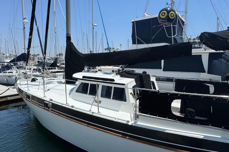 Slide: The Image of 1989 Gulf Pilot House sailboat docked in marina, featuring sleek design and black sail covers. - 4