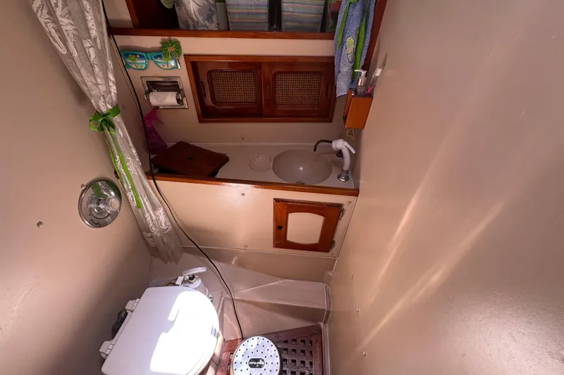 Slide: The Image of Compact 1989 Gulf Pilot House bathroom with sink, toilet, and wooden accents. - 40