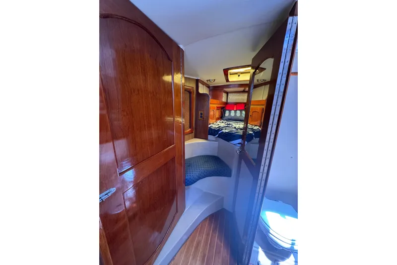 Slide: The Image of Interior of 1989 Gulf Pilot House boat with wooden finishes and cozy sleeping area. - 41