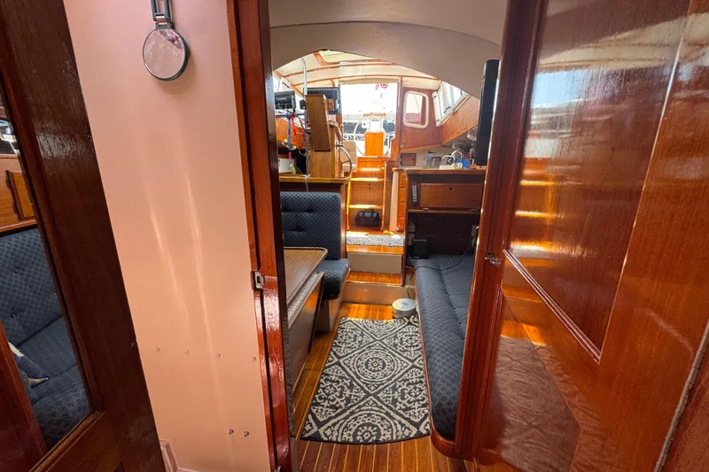 Slide: The Image of Interior of 1989 Gulf Pilot House boat with wooden finishes and seating area. - 44