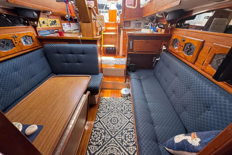 Slide: The Image of 1989 Gulf Pilot House interior with blue upholstery, wooden accents, and nautical decor. - 45