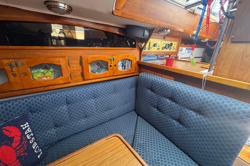 Slide: The Image of Cozy interior of a 1989 Gulf Pilot House boat with wooden cabinets and blue upholstery. - 48