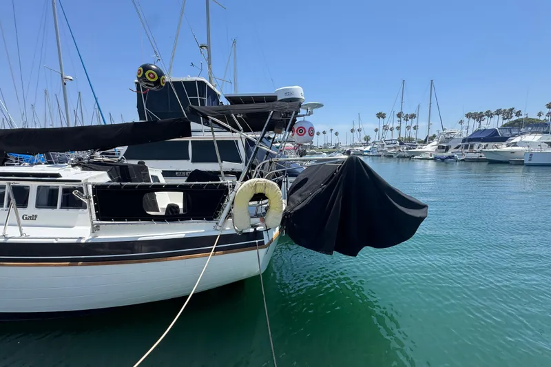 Slide: The Image of 1989 Gulf Pilot House yacht docked in a marina, surrounded by sailboats and clear blue water. - 5