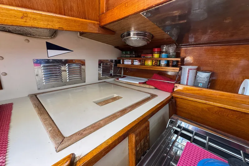 Slide: The Image of 1989 Gulf Pilot House kitchen with wooden cabinetry, spice rack, and stainless steel accents. - 59