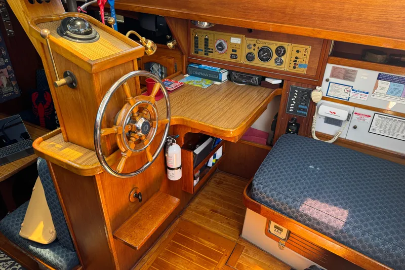 Slide: The Image of 1989 Gulf Pilot House interior with wooden helm, navigation instruments, and seating area. - 75