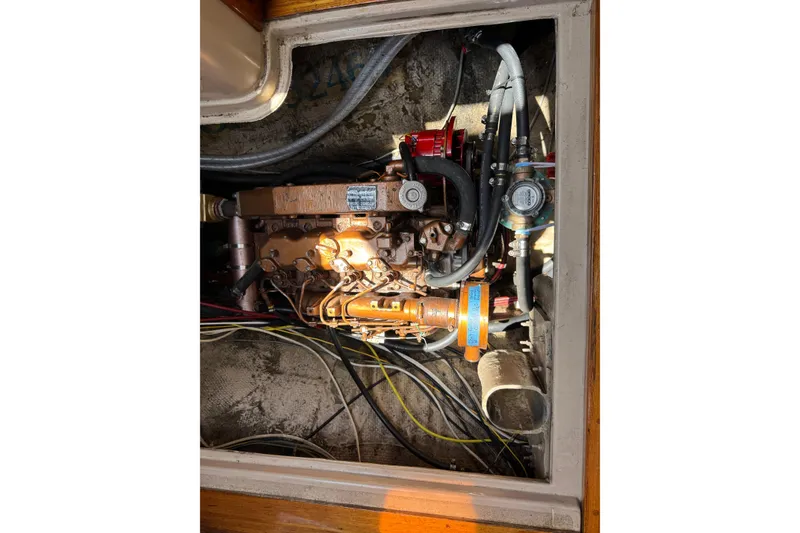 Slide: The Image of Engine compartment of a 1989 Gulf Pilot House boat, showing detailed mechanical components. - 77