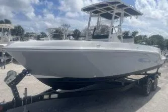 Slide: The Image of 2023 Trophy T22 boat on trailer under a partly cloudy sky. - 2