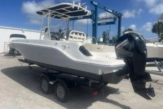 Slide: The Image of 2023 Trophy T22 boat on trailer with outboard motor, parked outdoors under blue sky. - 7