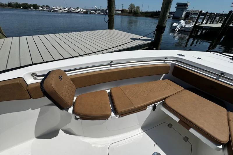Slide: The Image of 2024 Sea Pro 239 Deep V CC boat with tan cushioned seating at a dock. - 100