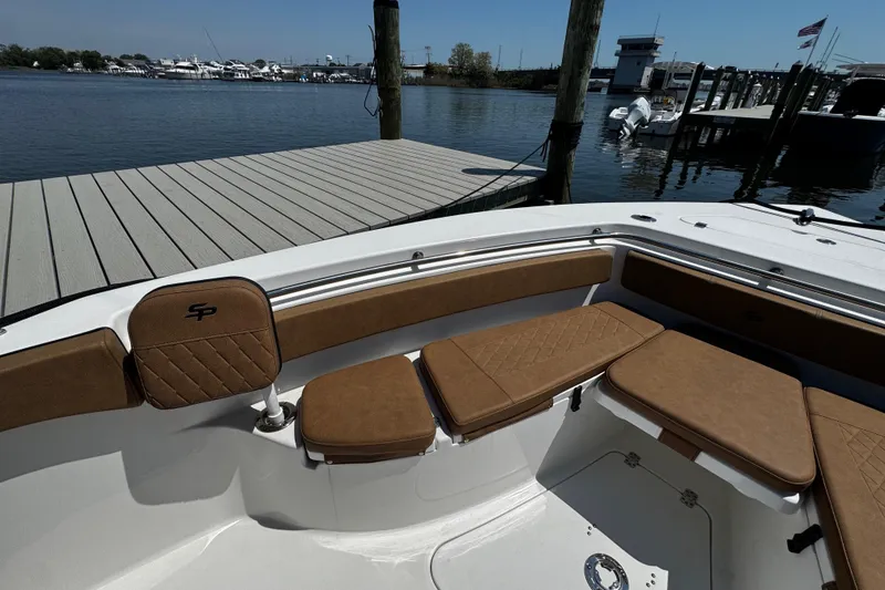 Slide: The Image of 2024 Sea Pro 239 Deep V CC boat interior with brown cushioned seating at dock. - 101
