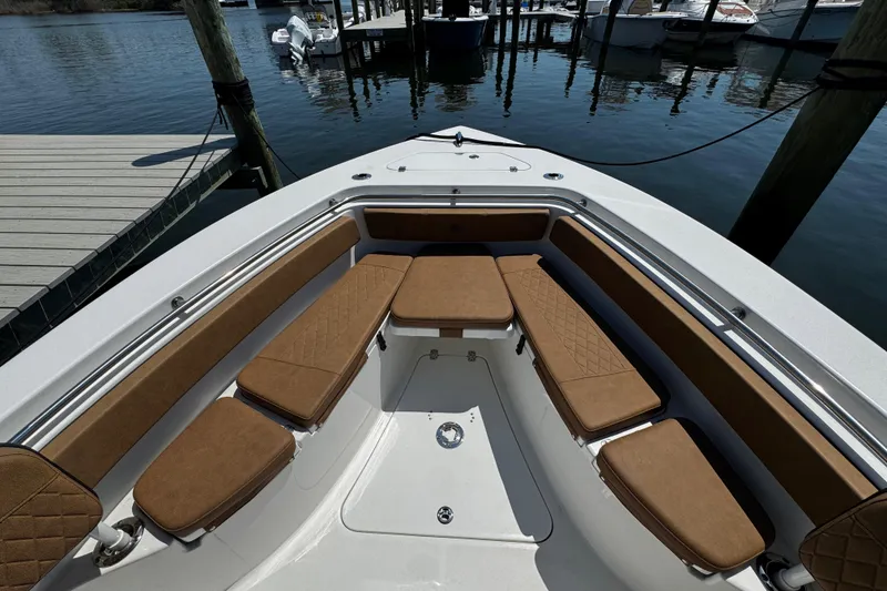Slide: The Image of 2024 Sea Pro 239 Deep V CC boat interior with brown cushioned seating at a dock. - 102