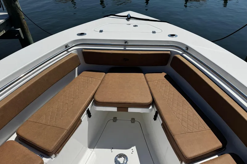 Slide: The Image of 2024 Sea Pro 239 Deep V CC boat with cushioned seating, docked on calm water. - 103