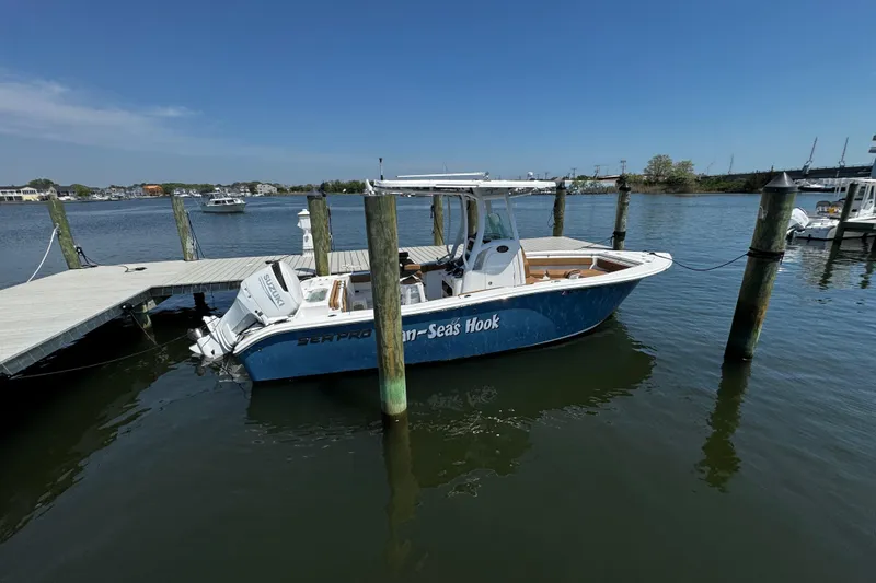 Slide: The Image of 2024 Sea Pro 239 Deep V CC boat docked on calm waters under clear blue sky. - 44