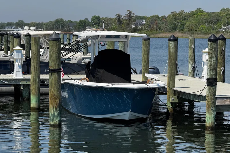 Slide: The Image of 2024 Sea Pro 239 Deep V CC boat docked at a marina, surrounded by calm water. - 45
