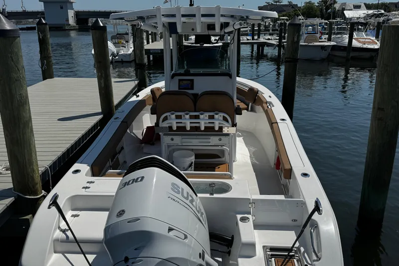 Slide: The Image of 2024 Sea Pro 239 Deep V CC boat docked, featuring a Suzuki 300 engine. - 47