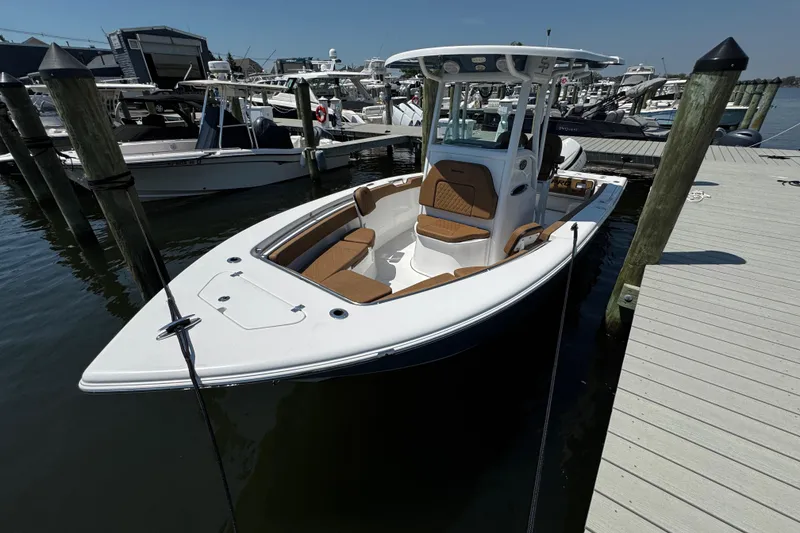 Slide: The Image of 2024 Sea Pro 239 Deep V CC boat docked at marina, showcasing sleek design and spacious seating. - 49