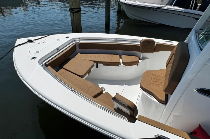 Slide: The Image of 2024 Sea Pro 239 Deep V CC boat with tan seating, docked on calm water. - 50