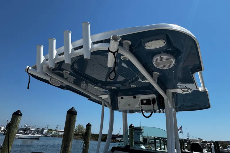 Slide: The Image of 2024 Sea Pro 239 Deep V CC boat with rod holders and electronics, docked under clear sky. - 54