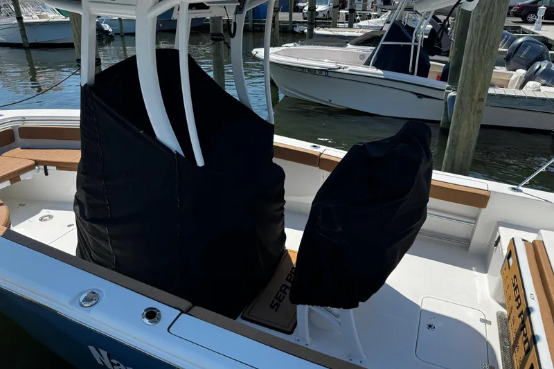 Slide: The Image of 2024 Sea Pro 239 Deep V CC boat interior with covered seats at a marina. - 57