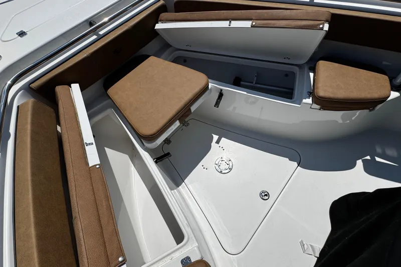 Slide: The Image of 2024 Sea Pro 239 Deep V CC boat interior with brown seating and storage compartments. - 58