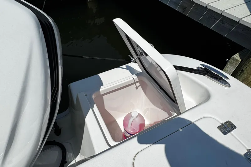 Slide: The Image of Open storage compartment on 2024 Sea Pro 239 Deep V CC boat with cleaning supplies. - 69