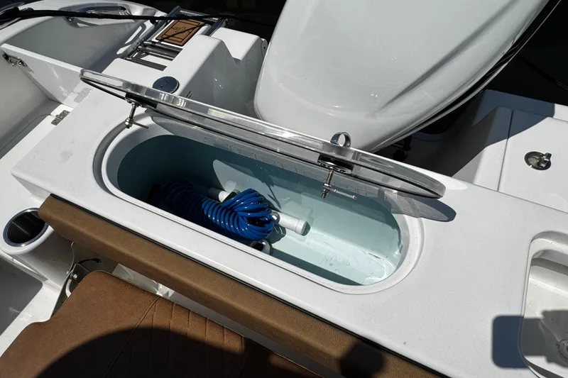 Slide: The Image of 2024 Sea Pro 239 Deep V CC boat with open storage compartment and coiled blue hose. - 70