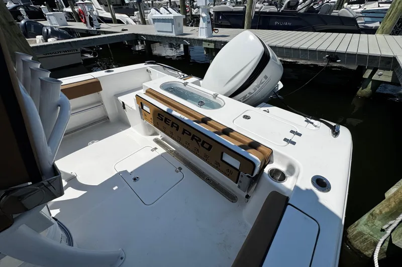 Slide: The Image of 2024 Sea Pro 239 Deep V CC boat docked, featuring Suzuki outboard motor. - 73