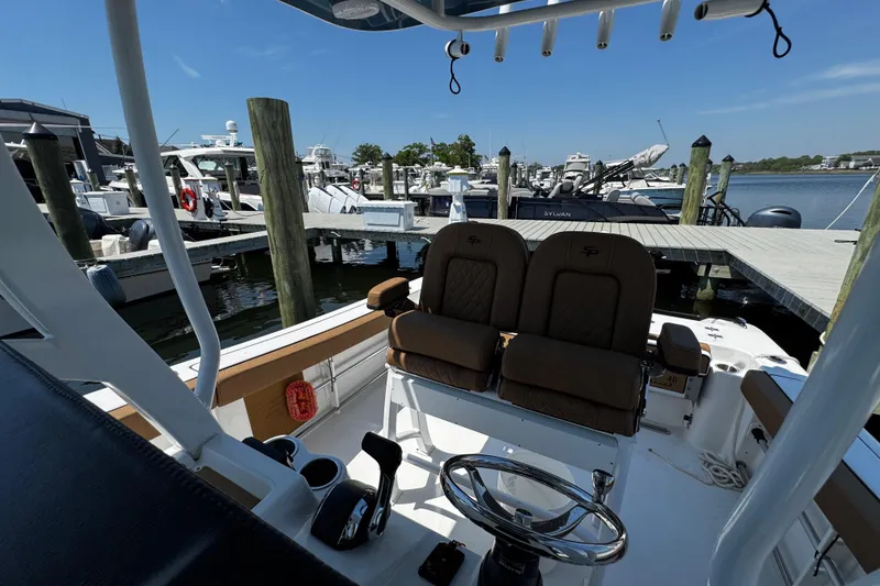 Slide: The Image of 2024 Sea Pro 239 Deep V CC boat docked at marina, featuring helm and seating. - 78
