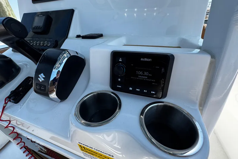 Slide: The Image of 2024 Sea Pro 239 Deep V CC dashboard with controls, radio, and cup holders. - 80