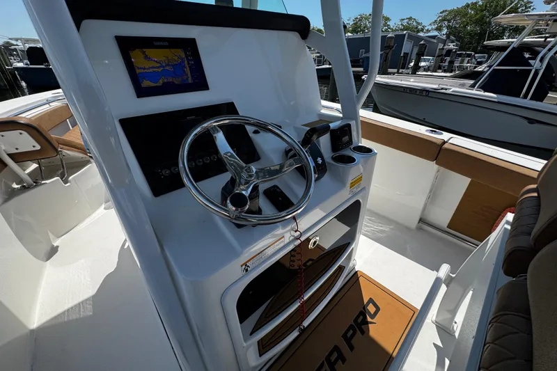 Slide: The Image of 2024 Sea Pro 239 Deep V CC boat helm with steering wheel and navigation display. - 81