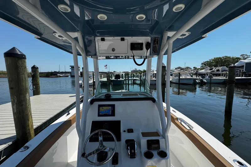 Slide: The Image of 2024 Sea Pro 239 Deep V CC boat at marina, featuring helm and navigation equipment. - 82
