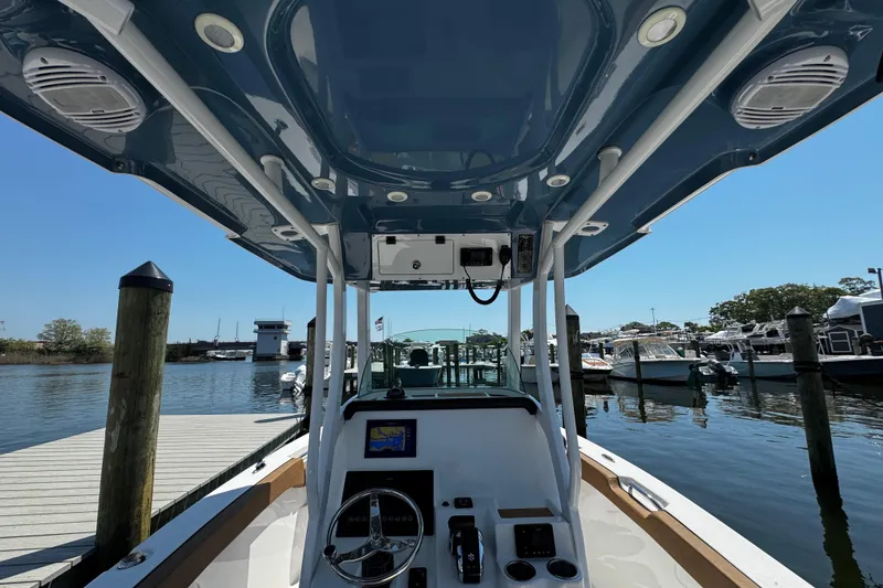 Slide: The Image of 2024 Sea Pro 239 Deep V CC boat at marina, showcasing helm and T-top. - 83