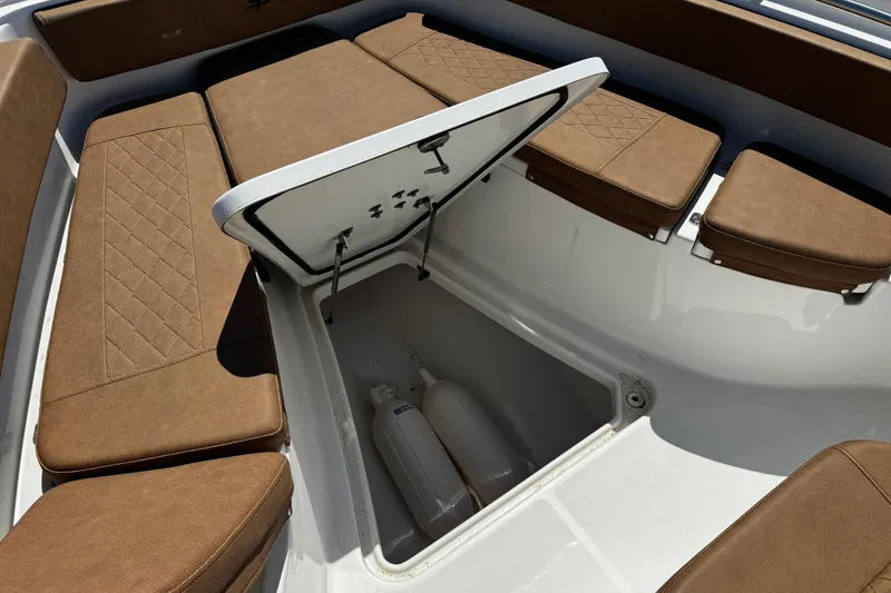 Slide: The Image of 2024 Sea Pro 239 Deep V CC boat with open storage compartment and cushioned seating. - 93