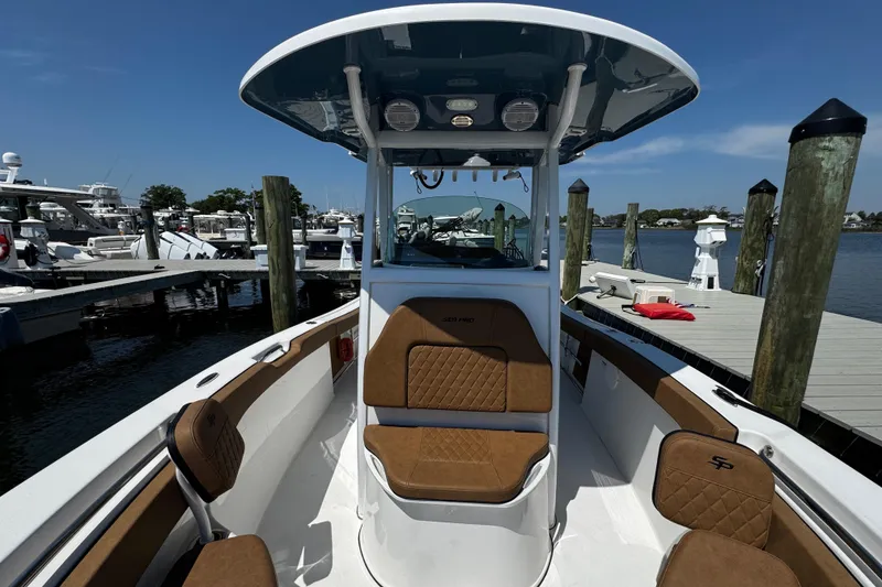 Slide: The Image of 2024 Sea Pro 239 Deep V CC boat docked, featuring brown seating and a sleek design. - 97