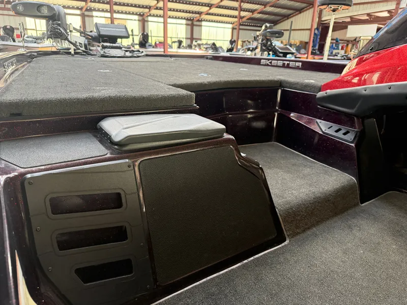 Slide: The Image of Interior of a 2017 Skeeter ZX225 boat, featuring padded deck and storage area. - 12