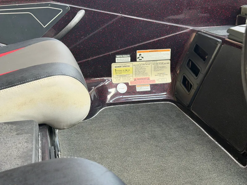 Slide: The Image of Interior of a 2017 Skeeter ZX225 boat with seat and warning labels. - 14
