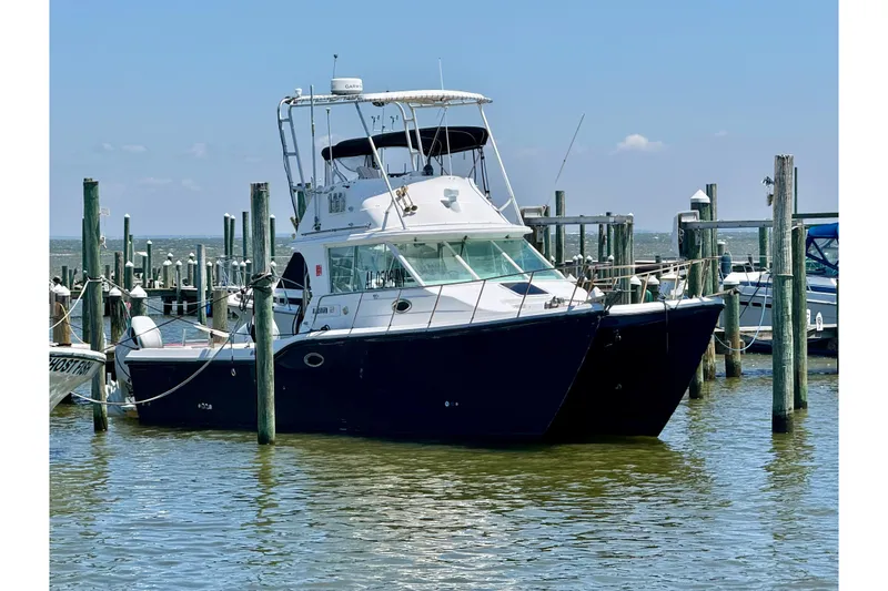 The Image of 2000 BAJA CRUISER King Cat 340 docked at marina under clear blue sky. - 0
