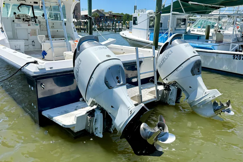 Slide: The Image of Twin Suzuki outboard motors on a 2000 BAJA CRUISER King Cat 340 boat docked in a marina. - 17
