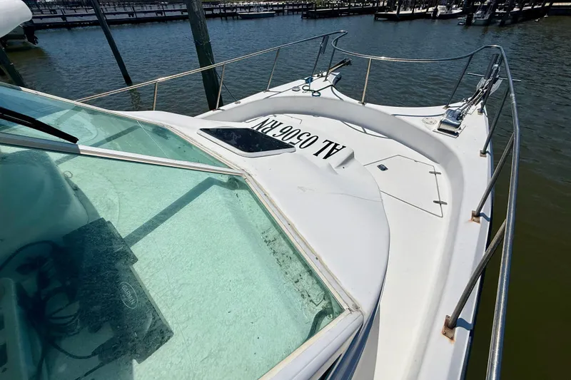 Slide: The Image of 2000 BAJA CRUISER King Cat 340 boat docked, featuring sleek white deck and railing. - 21