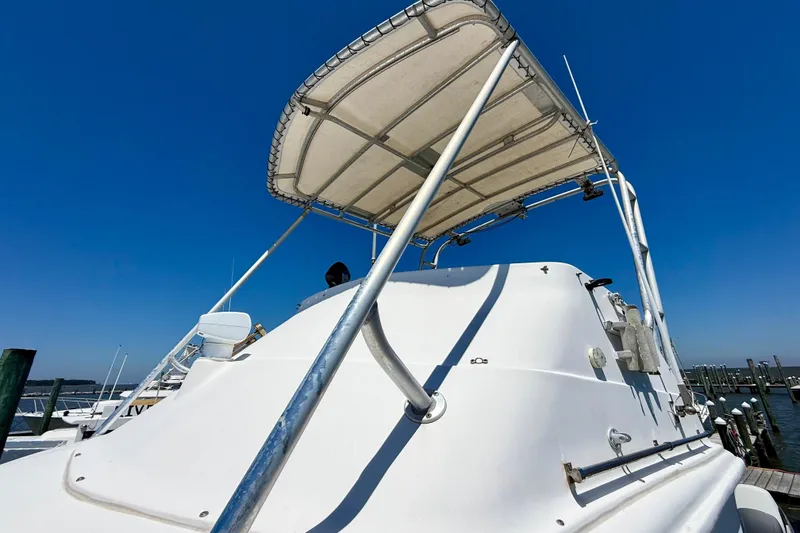 Slide: The Image of 2000 BAJA CRUISER King Cat 340 boat with canopy, docked under clear blue sky. - 26