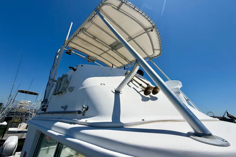 Slide: The Image of 2000 BAJA CRUISER King Cat 340 boat with canopy, docked under clear blue sky. - 27