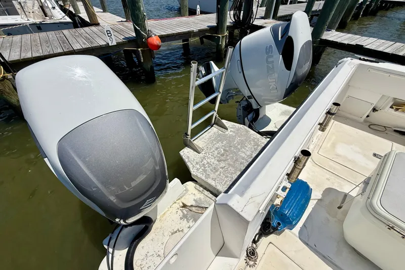 Slide: The Image of Twin Suzuki outboard motors on a 2000 BAJA CRUISER King Cat 340 at a dock. - 29