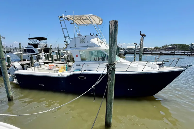 Slide: The Image of 2000 BAJA CRUISER King Cat 340 docked at marina, clear sky background. - 4