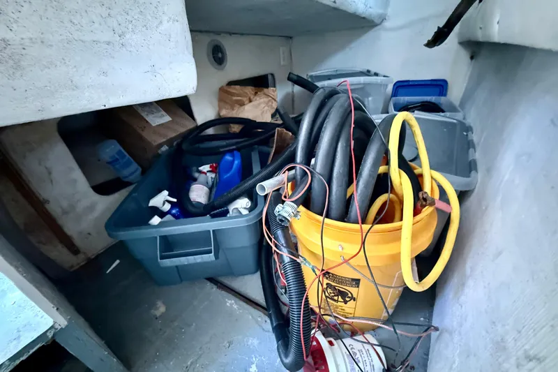 Slide: The Image of Storage area in a 2000 BAJA CRUISER King Cat 340 with hoses and cleaning supplies. - 48