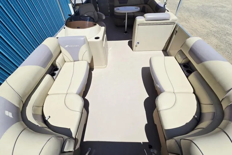 Slide: The Image of 2019 Starcraft EX 20 C pontoon boat interior with beige seating and table. - 11