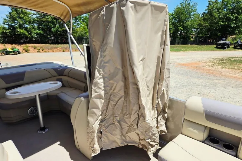 Slide: The Image of 2019 Starcraft EX 20 C pontoon boat interior with seating, table, and privacy curtain. - 13